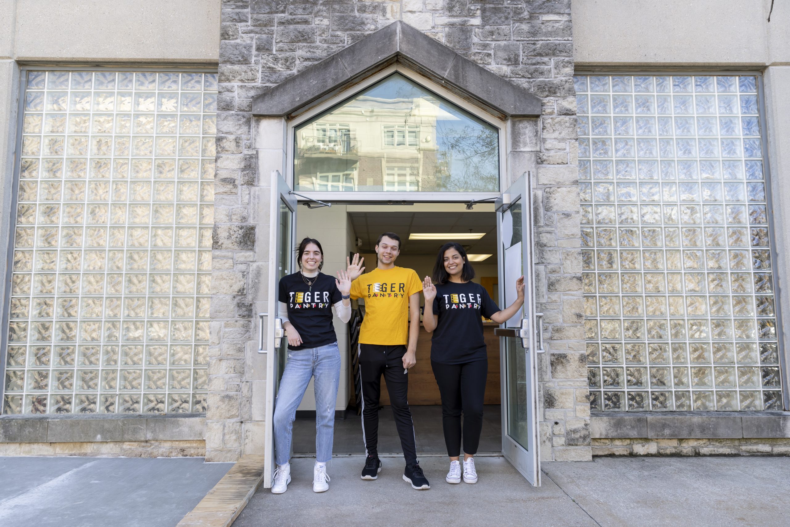 Students stand and wave outside of Tiger Pantry