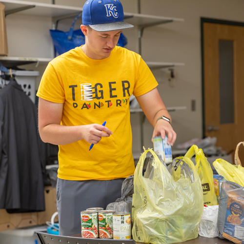 Student bags groceries at Tiger Pantry